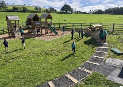 Disgyblion yn chwarae ym mharc yr ysgol / Pupils playing in the school play park
